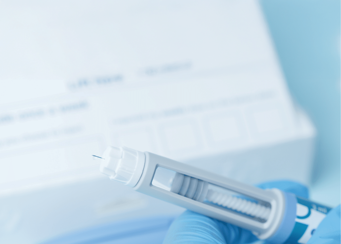 Close up on a needle on diabetic medication pen. Hands with blue glowes taping pen. High quality photo